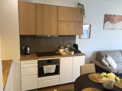 a kitchen with white cabinets and a stove at Browar Lubicz by Atrium Apartments in Kraków