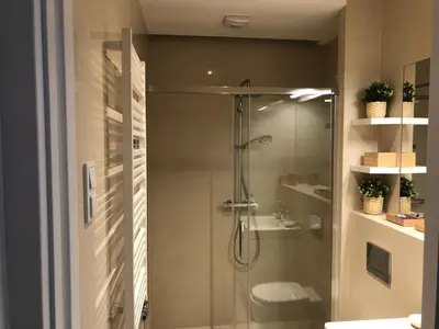 a bathroom with a shower with a toilet and a sink at Browar Lubicz by Atrium Apartments in Kraków
