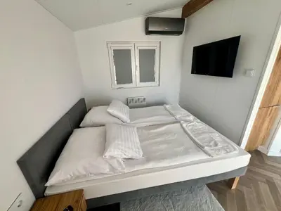 a bed in a room with a tv on the wall at Hotel Nad Stawem in Skalbmierz