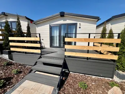 a house with two wooden benches in front of it at Hotel Nad Stawem in Skalbmierz