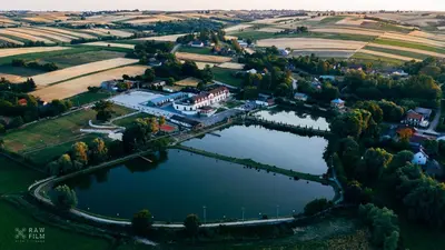 an aerial view of a large house on a lake at Hotel Nad Stawem in Skalbmierz