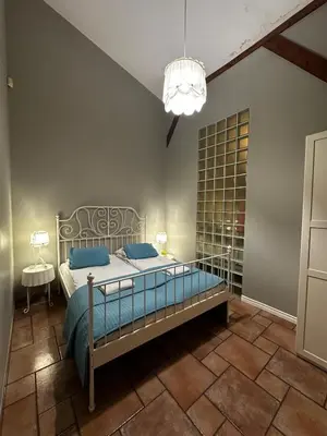a bedroom with a bed with blue pillows and a chandelier at FLORIANSKA Penthouse DeLux in Kraków