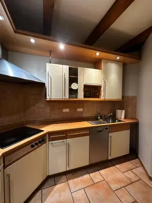 a kitchen with white cabinets and a sink at FLORIANSKA Penthouse DeLux in Kraków