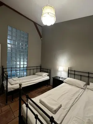 a bedroom with two beds and a lamp and a window at FLORIANSKA Penthouse DeLux in Kraków