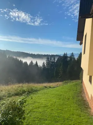 a room with a view of a grassy field and trees at Apartament w górach Gorce in Nowy Targ