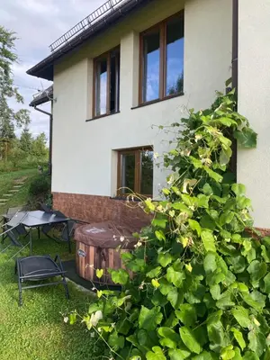 a house with a large green bush in front of it at Apartament w górach Gorce in Nowy Targ