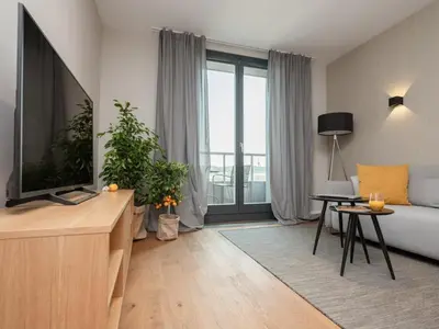 a living room with a couch and a tv at Stylish Apartment Luminis in Krakow's Kazimierz in Kraków