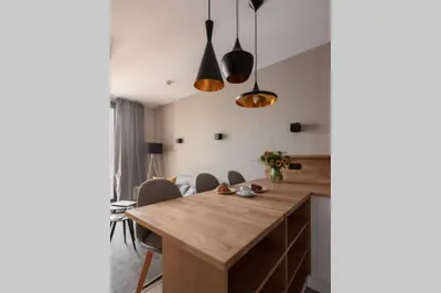 a kitchen with a wooden table and chairs at Stylish Apartment Luminis in Krakow's Kazimierz in Kraków