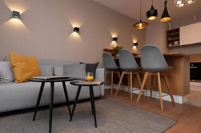 a living room with a couch and chairs and a kitchen at Stylish Apartment Luminis in Krakow's Kazimierz in Kraków