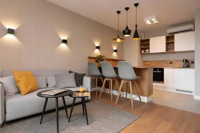 a living room with a couch and a kitchen at Stylish Apartment Luminis in Krakow's Kazimierz in Kraków