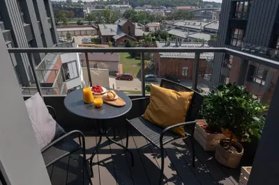 a balcony with a table and chairs on a balcony at Stylish Apartment Luminis in Krakow's Kazimierz in Kraków