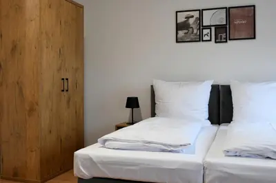 a bedroom with two beds and a wooden door at ZatorHome apartamenty - blisko Energylandii i Zatorlandu in Zator