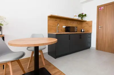 a kitchen with a wooden table and a counter at ZatorHome apartamenty - blisko Energylandii i Zatorlandu in Zator
