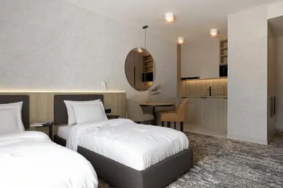 a hotel room with two beds and a kitchen at ZatorHome apartamenty - blisko Energylandii i Zatorlandu in Zator