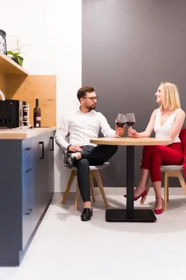 a man and woman sitting at a table with wine glasses at ZatorHome apartamenty - blisko Energylandii i Zatorlandu in Zator