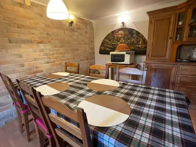 a dining room with a table and chairs and a microwave at Domek w Lesie in Łęki