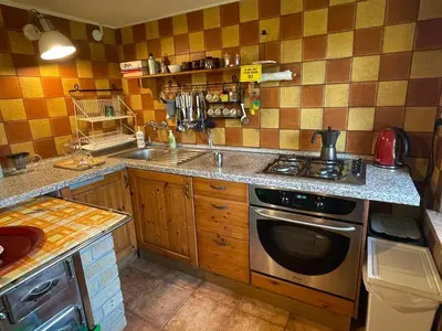 a kitchen with a sink and a stove top oven at Domek w Lesie in Łęki
