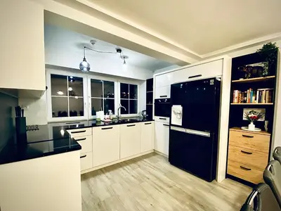 a kitchen with white cabinets and a black refrigerator at LaVerde - Blisko Przyrody Daleko od Tłumu in Skomielna Czarna