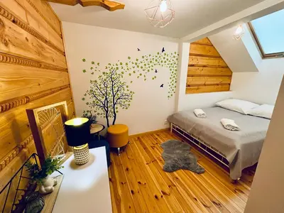 a bedroom with a bed and a tree on the wall at LaVerde - Blisko Przyrody Daleko od Tłumu in Skomielna Czarna