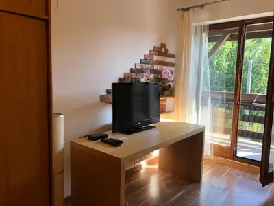 a television on a desk in a room with a window at Apartament Bronowice in Kraków