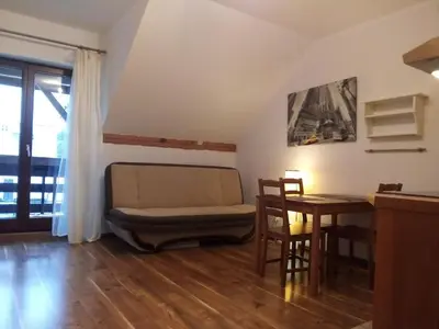 a living room with a couch and a table at Apartament Bronowice in Kraków