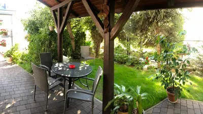 a patio with a table and chairs under a gazebo at Apartament Bronowice in Kraków
