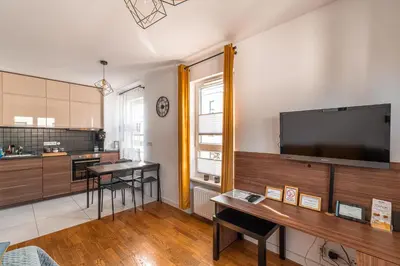 a living room with a large flat screen tv on the wall at Apartament Chmielna Loft in Kraków