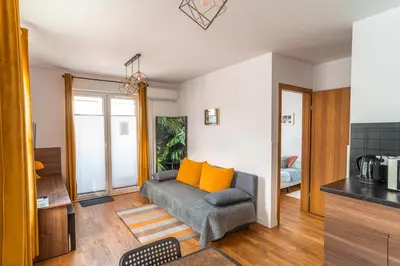 a living room with a couch with orange pillows at Apartament Chmielna Loft in Kraków
