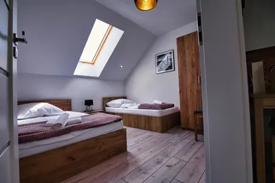 two beds in a room with a window at Blue Sky - Apartamenty Premium Zator in Zator