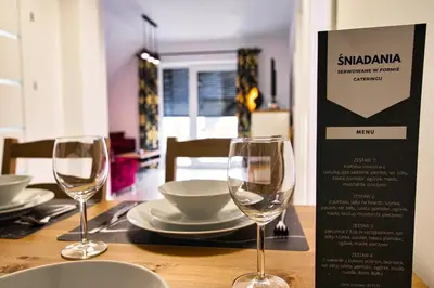 two wine glasses sitting on a wooden table at Blue Sky - Apartamenty Premium Zator in Zator