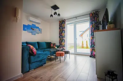 a living room with a blue couch and a table at Blue Sky - Apartamenty Premium Zator in Zator