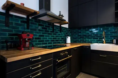 a kitchen with black cabinets and a red mixer at PRZEPIĘKNY APARTAMENT w sercu Starego Miasta in Kraków