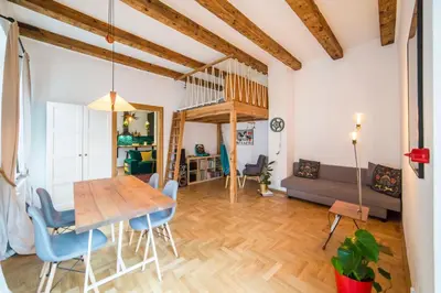 a dining room and living room with a table and chairs at PRZEPIĘKNY APARTAMENT w sercu Starego Miasta in Kraków