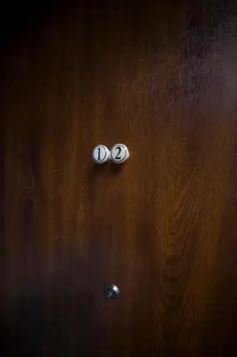 a close up of a wooden door with two buttons at PRZEPIĘKNY APARTAMENT w sercu Starego Miasta in Kraków