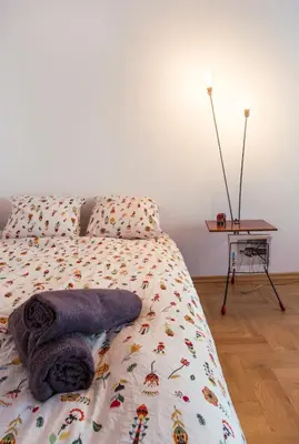 a bedroom with a bed with a table and a bedspread with bugs at PRZEPIĘKNY APARTAMENT w sercu Starego Miasta in Kraków