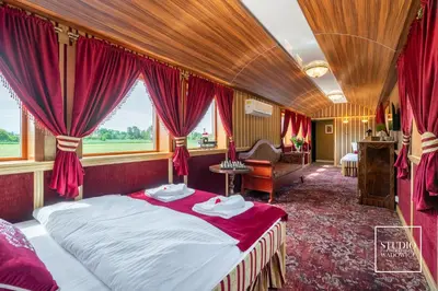 a bedroom with a bed in a room with red curtains at Stacja Galicja - nocleg w pociągu blisko Energylandia in Zator