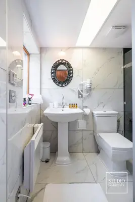 a white bathroom with a sink and a toilet at Stacja Galicja - nocleg w pociągu blisko Energylandia in Zator