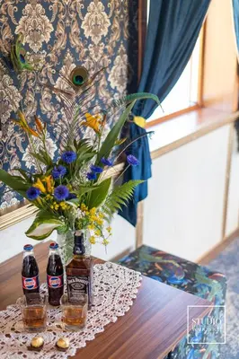 a table with two bottles and a vase with flowers at Stacja Galicja - nocleg w pociągu blisko Energylandia in Zator