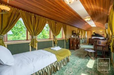 a bedroom with a bed in a room with windows at Stacja Galicja - nocleg w pociągu blisko Energylandia in Zator