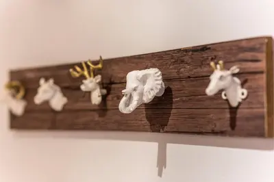 a wooden shelf with four animal heads on it at WSPANIAŁY, Stylowy Apartament w Sercu Starego Miasta in Kraków