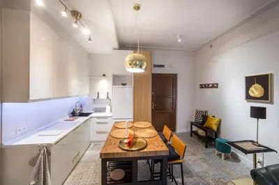 a kitchen and dining room with a table and chairs at WSPANIAŁY, Stylowy Apartament w Sercu Starego Miasta in Kraków