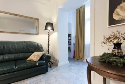 a living room with a green couch and a table at WSPANIAŁY, Stylowy Apartament w Sercu Starego Miasta in Kraków