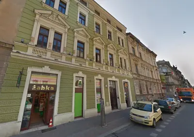 a green building with a car parked in front of it at WSPANIAŁY, Stylowy Apartament w Sercu Starego Miasta in Kraków