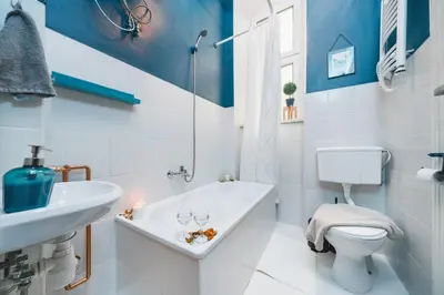 a bathroom with a tub and a toilet and a sink at Krasińskiego Apartments - LOW STANDARD - Riverside & Old Town - by Upstairs in Kraków