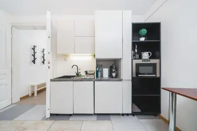 a kitchen with white cabinets and a sink at Krasińskiego Apartments - LOW STANDARD - Riverside & Old Town - by Upstairs in Kraków