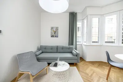 a living room with a couch and a table and chairs at Native Apartments Żuławskiego 8 in Kraków