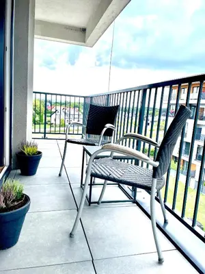 two chairs and a table on a balcony at Froja in Zator