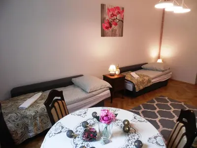 a living room with a table and a couch at Apartament Orchidea in Kraków