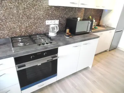 a kitchen with a stove and a microwave at Apartament Orchidea in Kraków