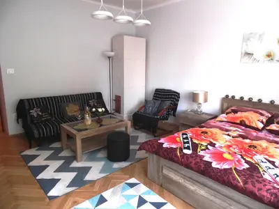 a bedroom with a bed and a couch and a table at Apartament Orchidea in Kraków